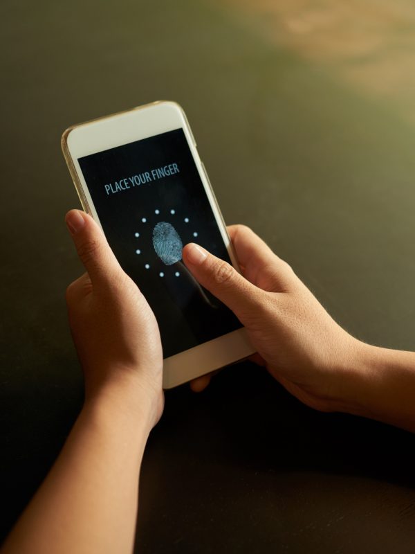 cropped-hands-scanning-fingerprint-smartphone