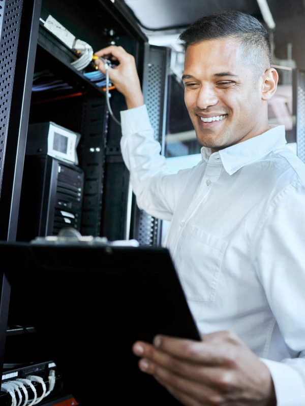 Server room, IT support and database with a man programmer working on a mainframe in a data center
